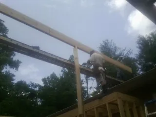 Carpenter setting a ridge beam over a new addition frame — Ice Dam Removal by Roofing Brothers in Eola