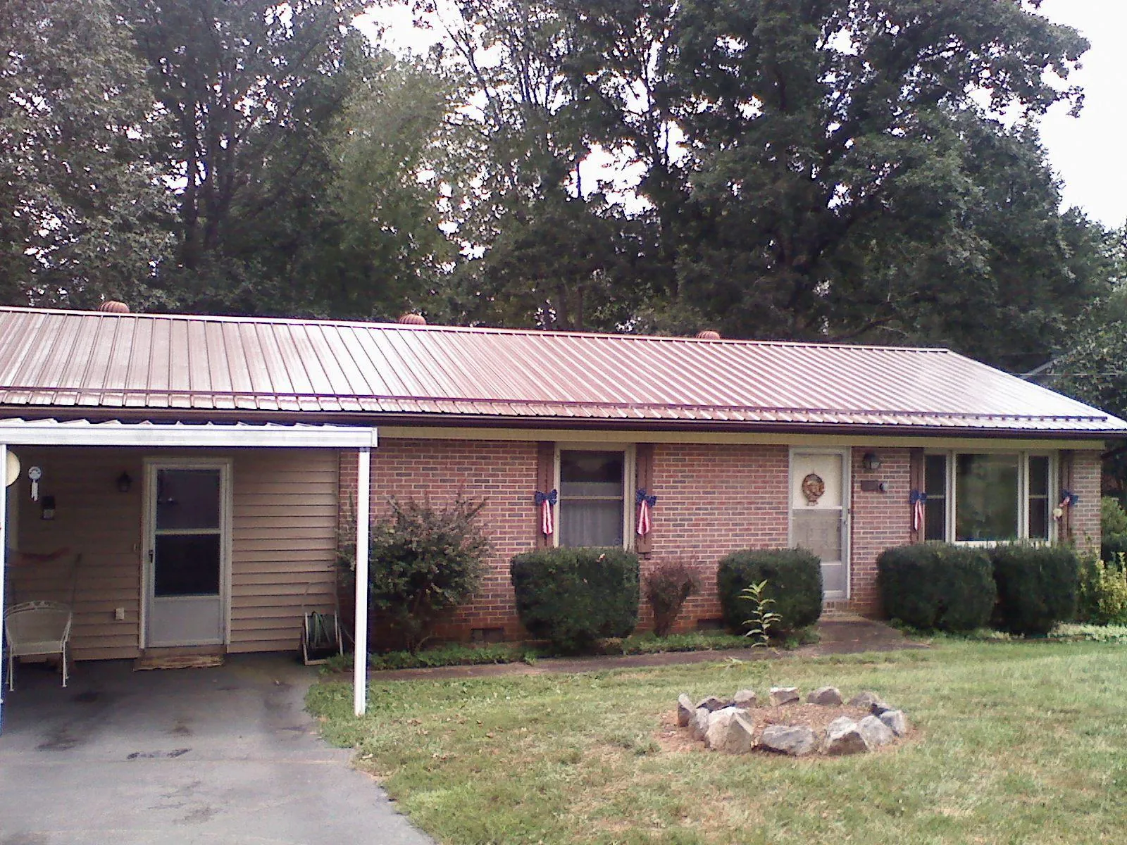 Bronze metal roof and carport on a brick ranch home — Roof Repair work by our crew in Eola